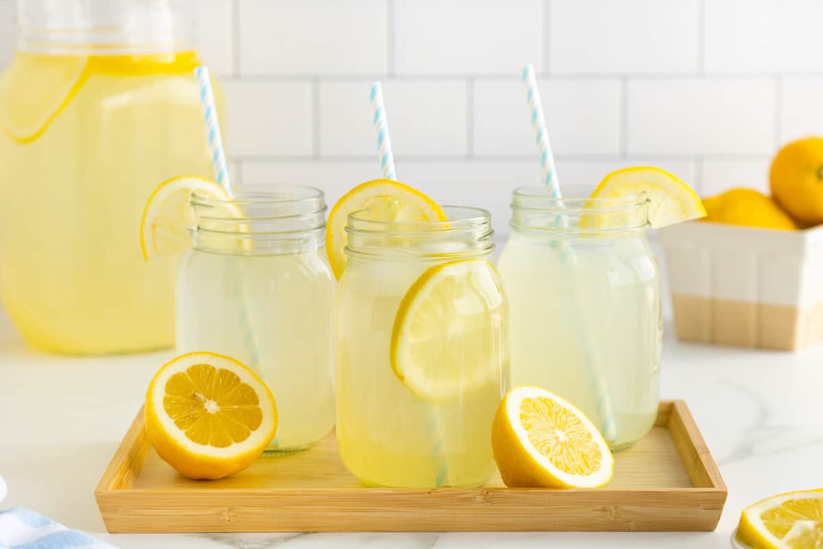 fresh lemonade in mason jars with slices of lemons
