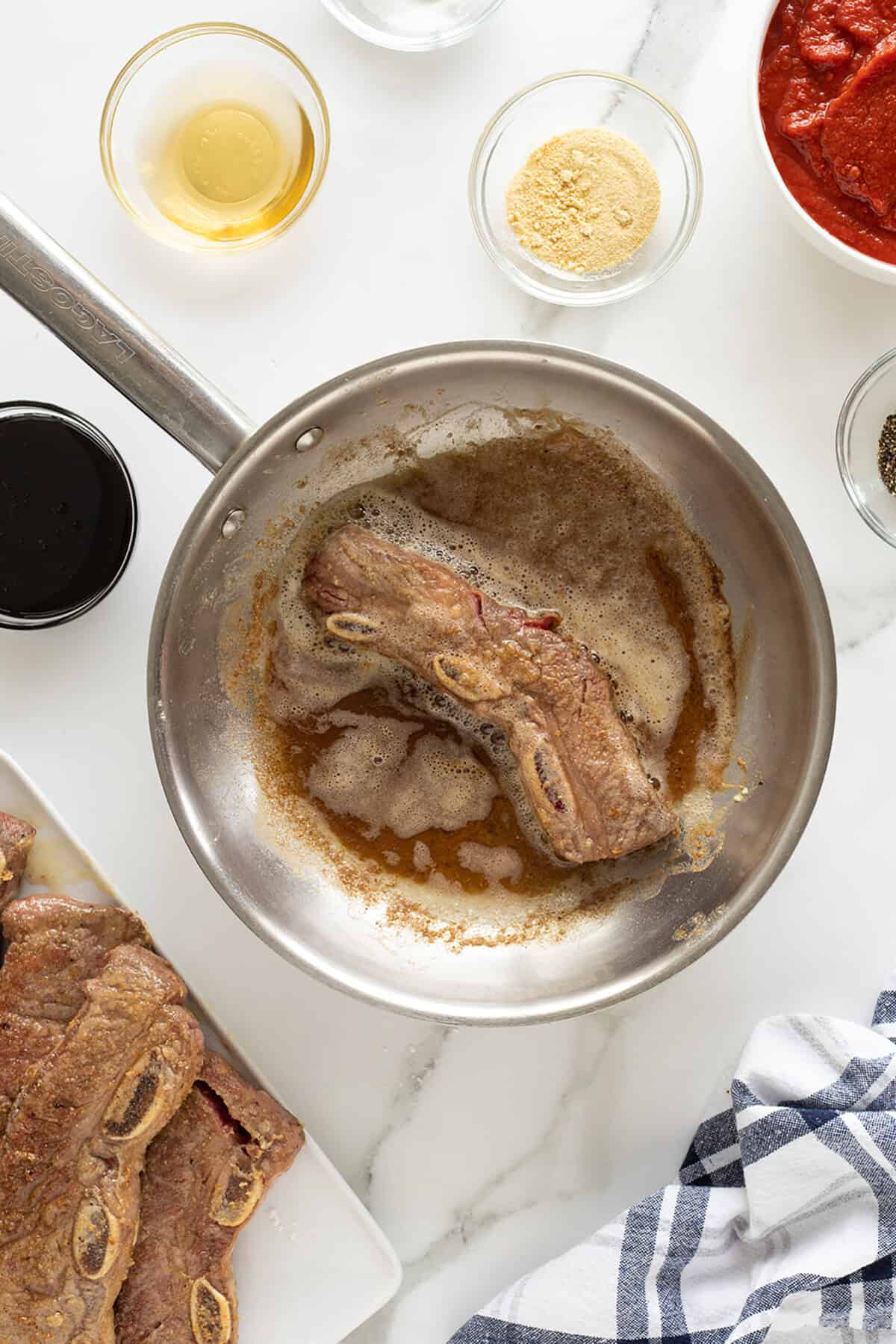 slow cooker short ribs frying in a pan