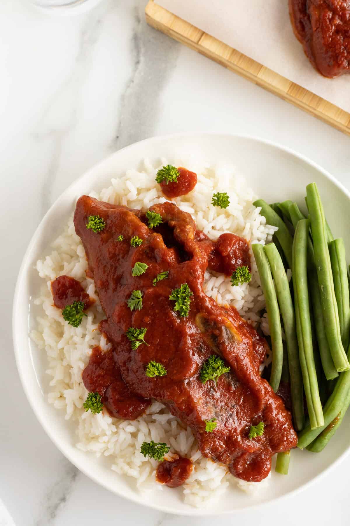 slow cooker short ribs on a plate with rice and green beans on the side