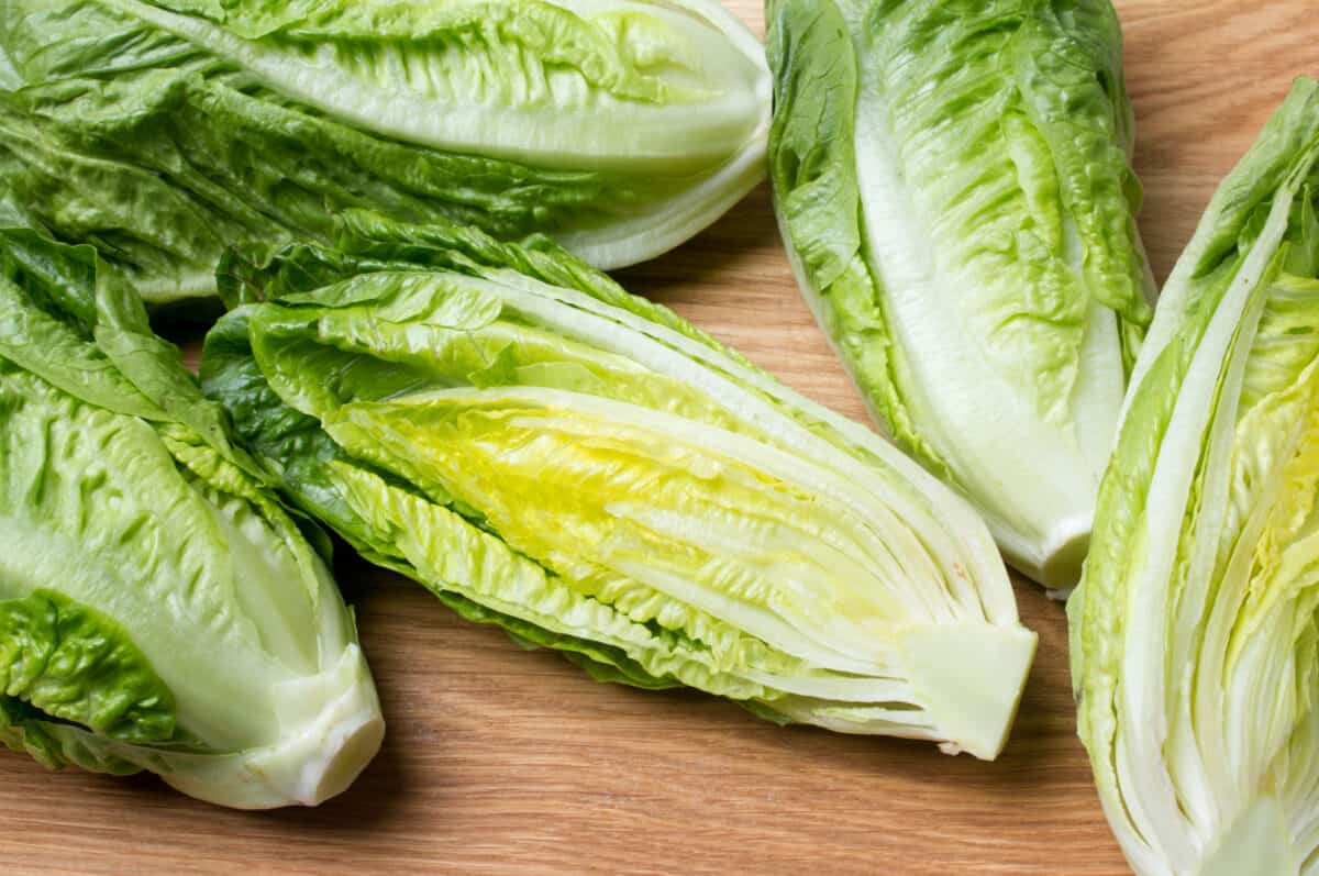romaine lettuce sliced lengthwise on a cuttingboard