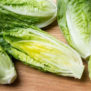 romaine lettuce sliced lengthwise on a cuttingboard