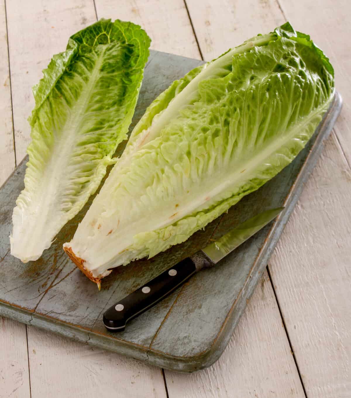 uncut romaine lettuce on a cutting board with a knife