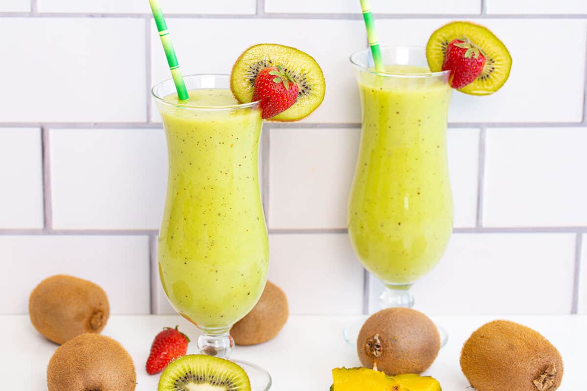 two kiwi smoothies on a white background