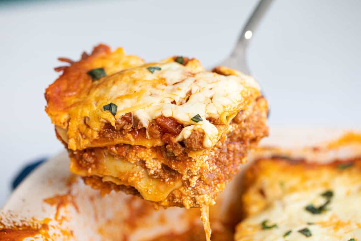 a close up of a scoop of ravioli lasagna on a serving spoon.