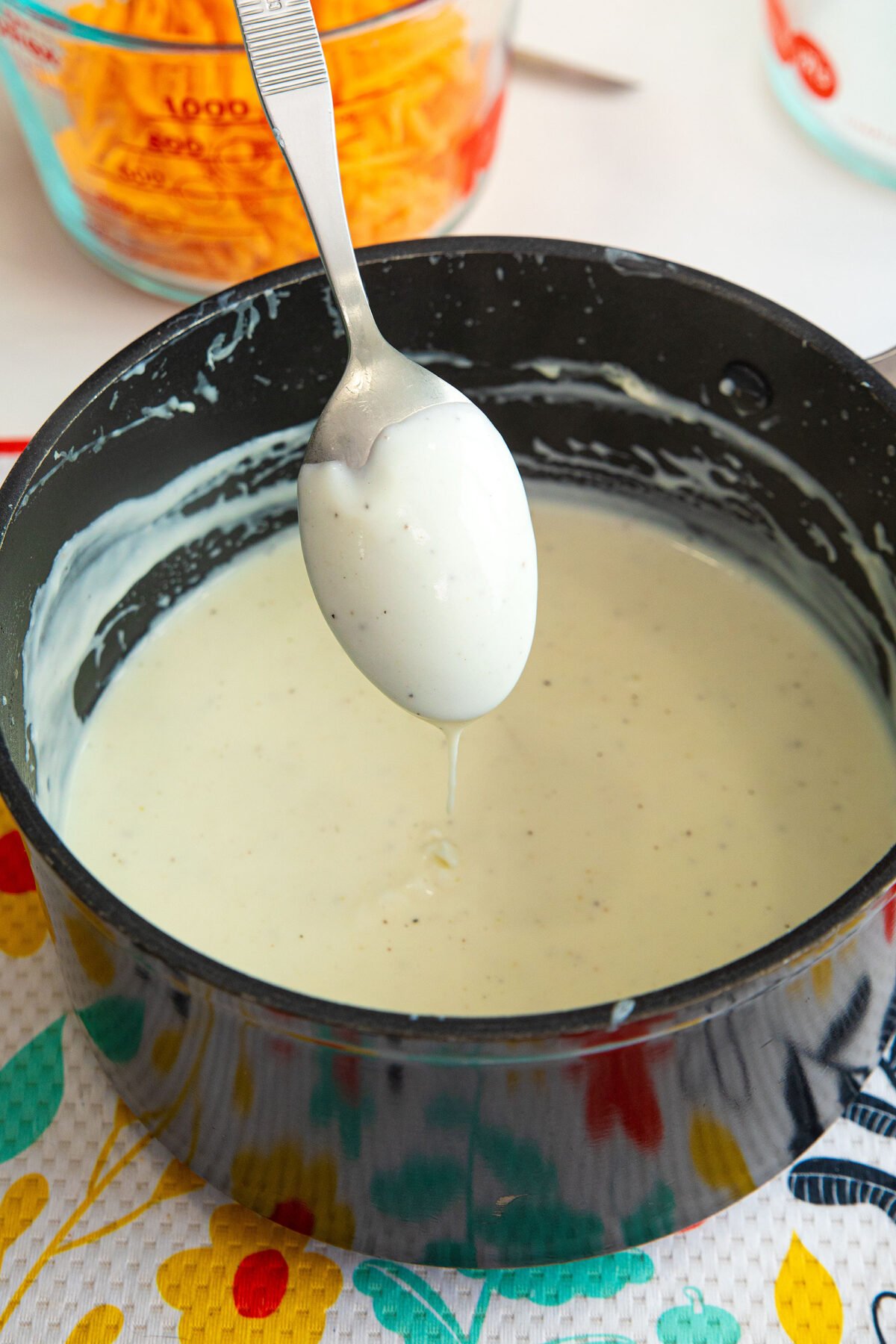Béchamel sauce coating the back of a spoon