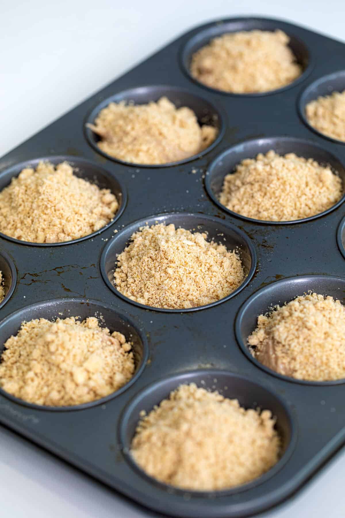 streusel topping sprinkled on top of unbaked muffins 