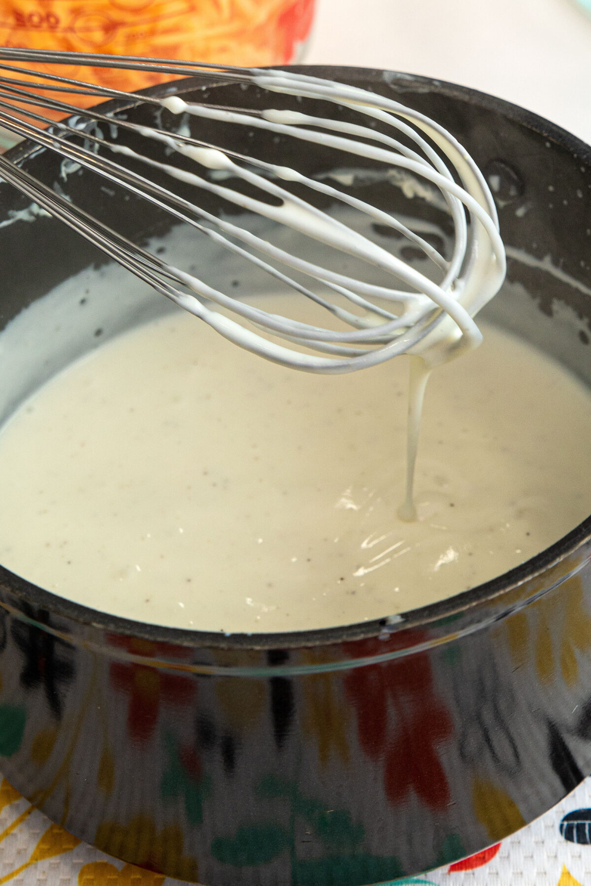Béchamel sauce on a wire whisk