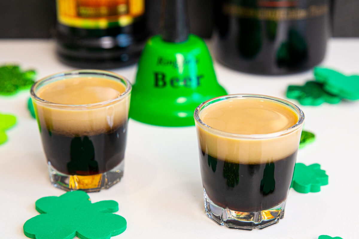 Baby Guinness Shot on a white counter with the ingredients in the background.