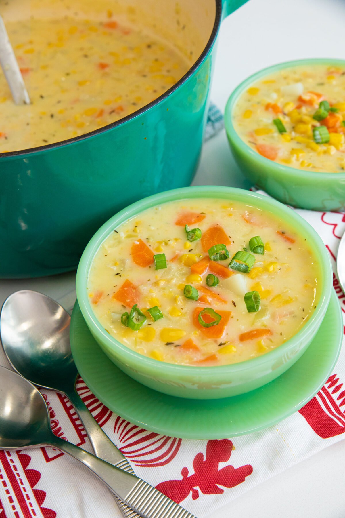 two bowls of corn soup and a pot of soup