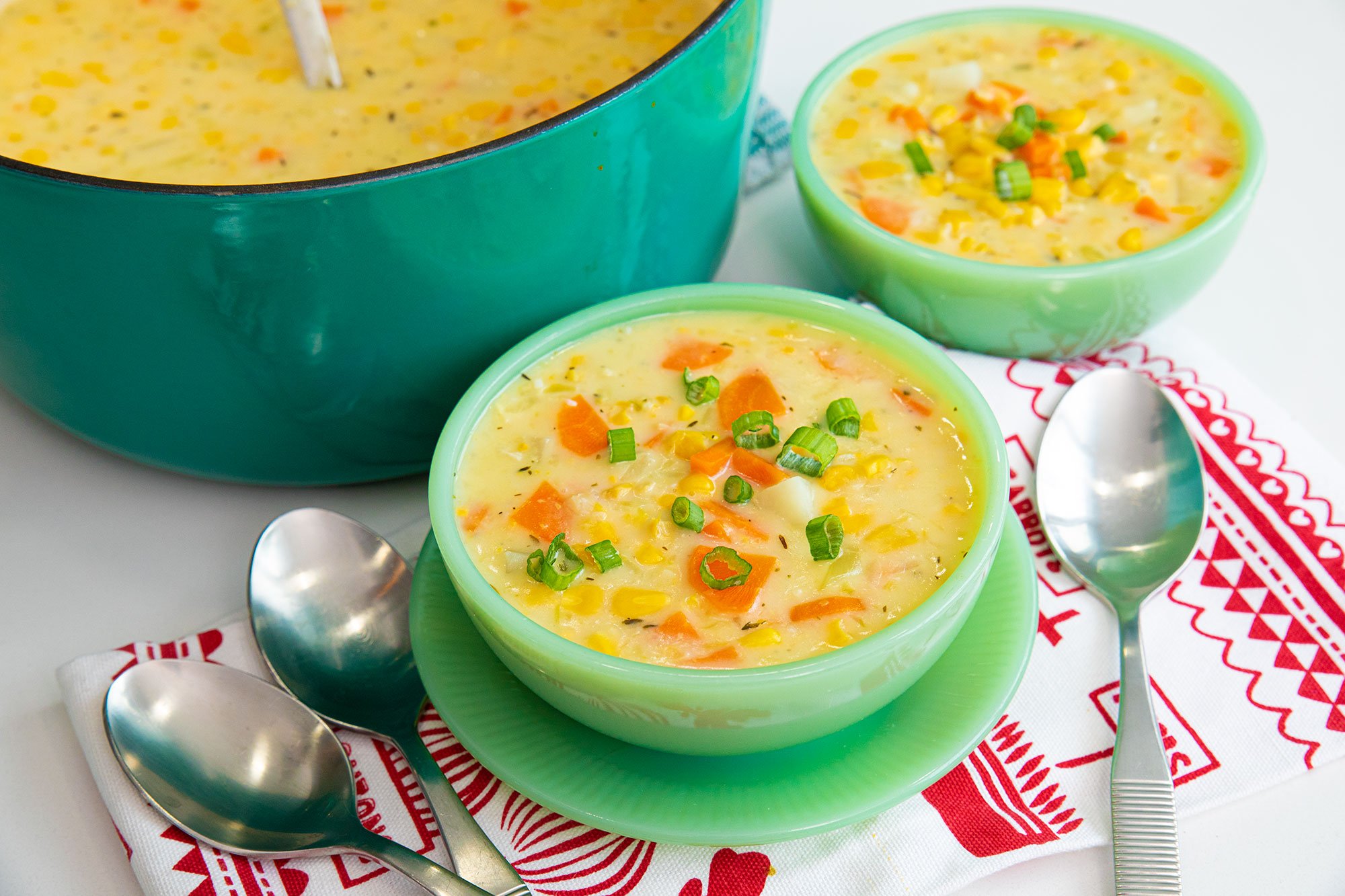 Smooth and creamy corn soup garnished with fresh herbs and cracked pepper.