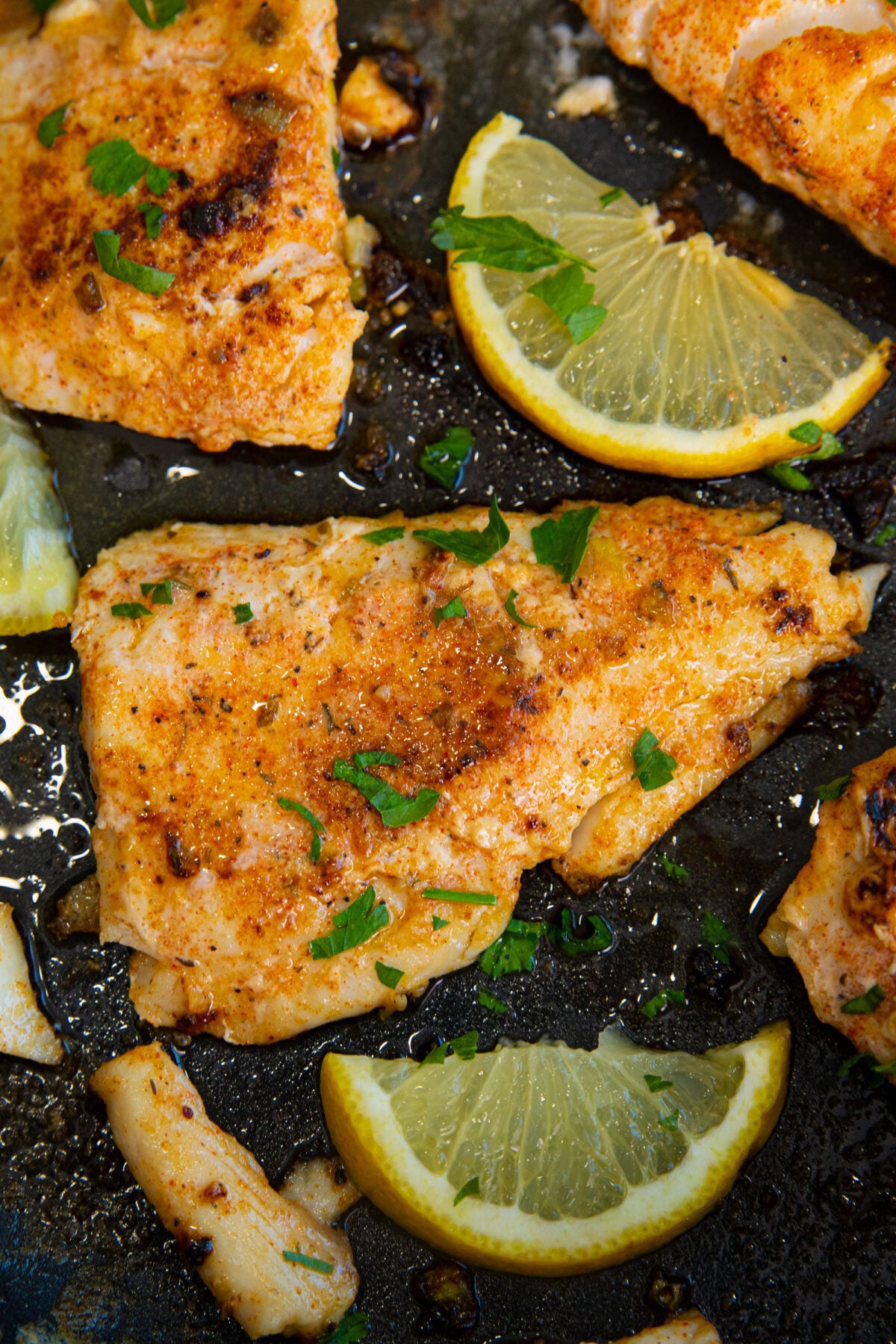 Affordable and healthy, cod is a mild-tasting white fish that is delicious when pan-fried in butter with Cajun seasonings and garnished with lemon juice. A fast meal that is perfect for any day of the week! #thekitchenmagpie #cod #bakedcod #familymeals a large piece of pan fried cod