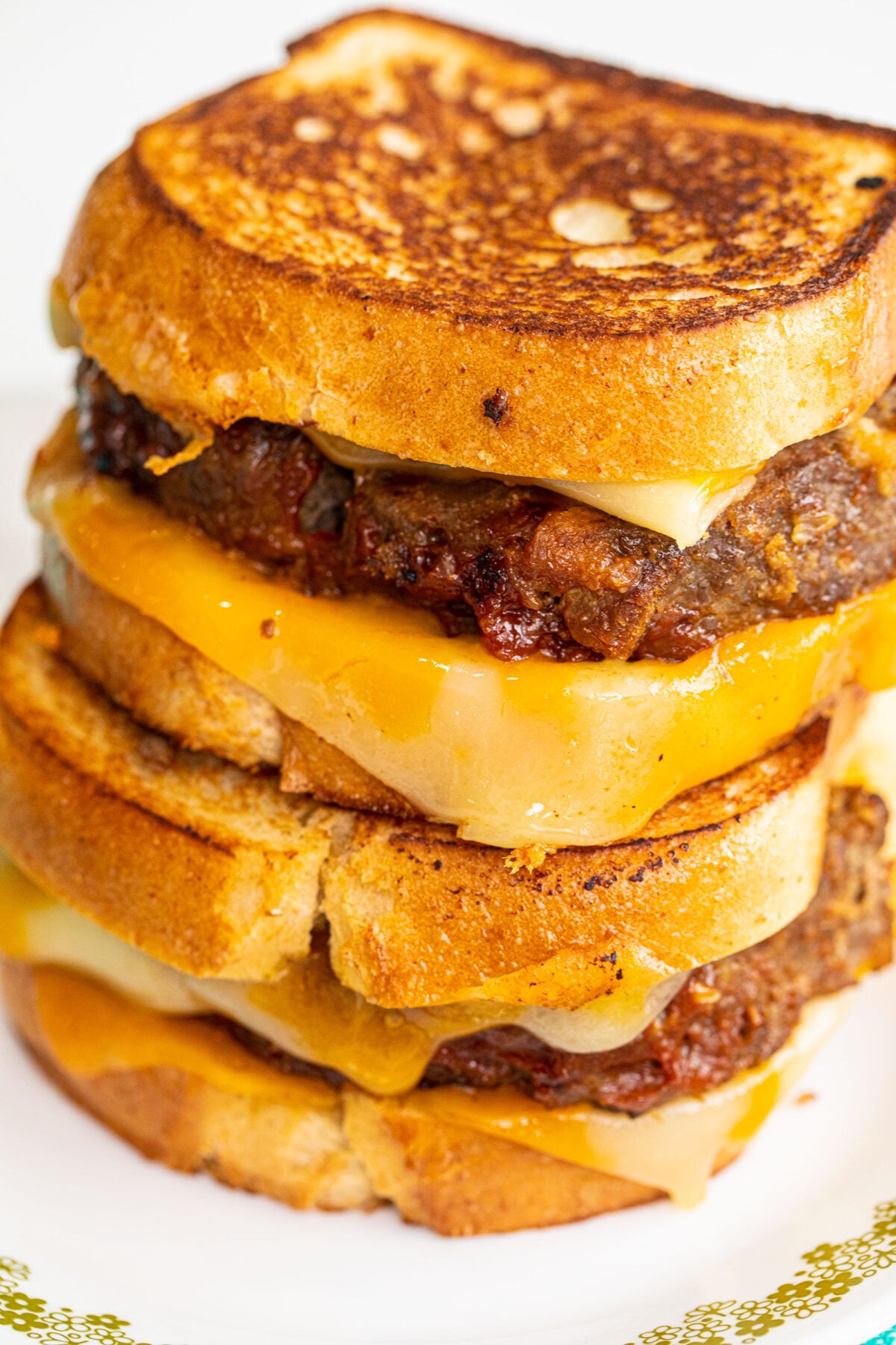 Full shot of a meatloaf sandwich, up close with cheese.