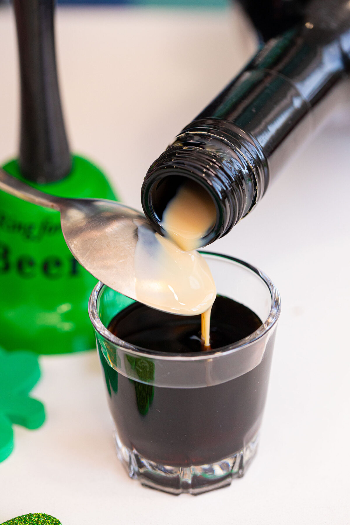 Pouring the Irish Cream over a spoon to create a floating layer.