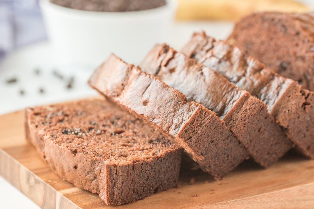 sliced chocolate banana bread laying on its side on a cutting board.