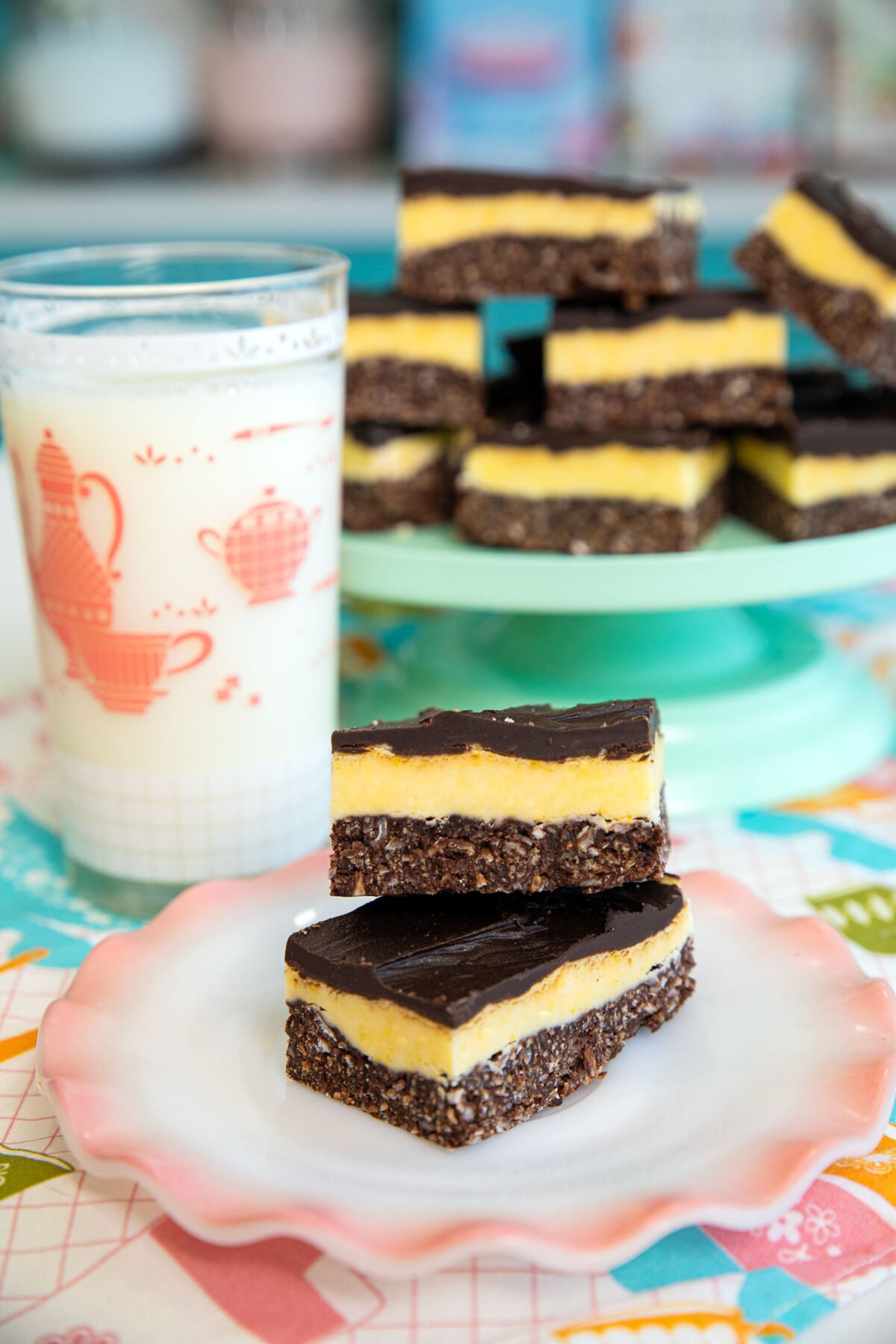 Nanaimo bars on a plate with a glass of milk