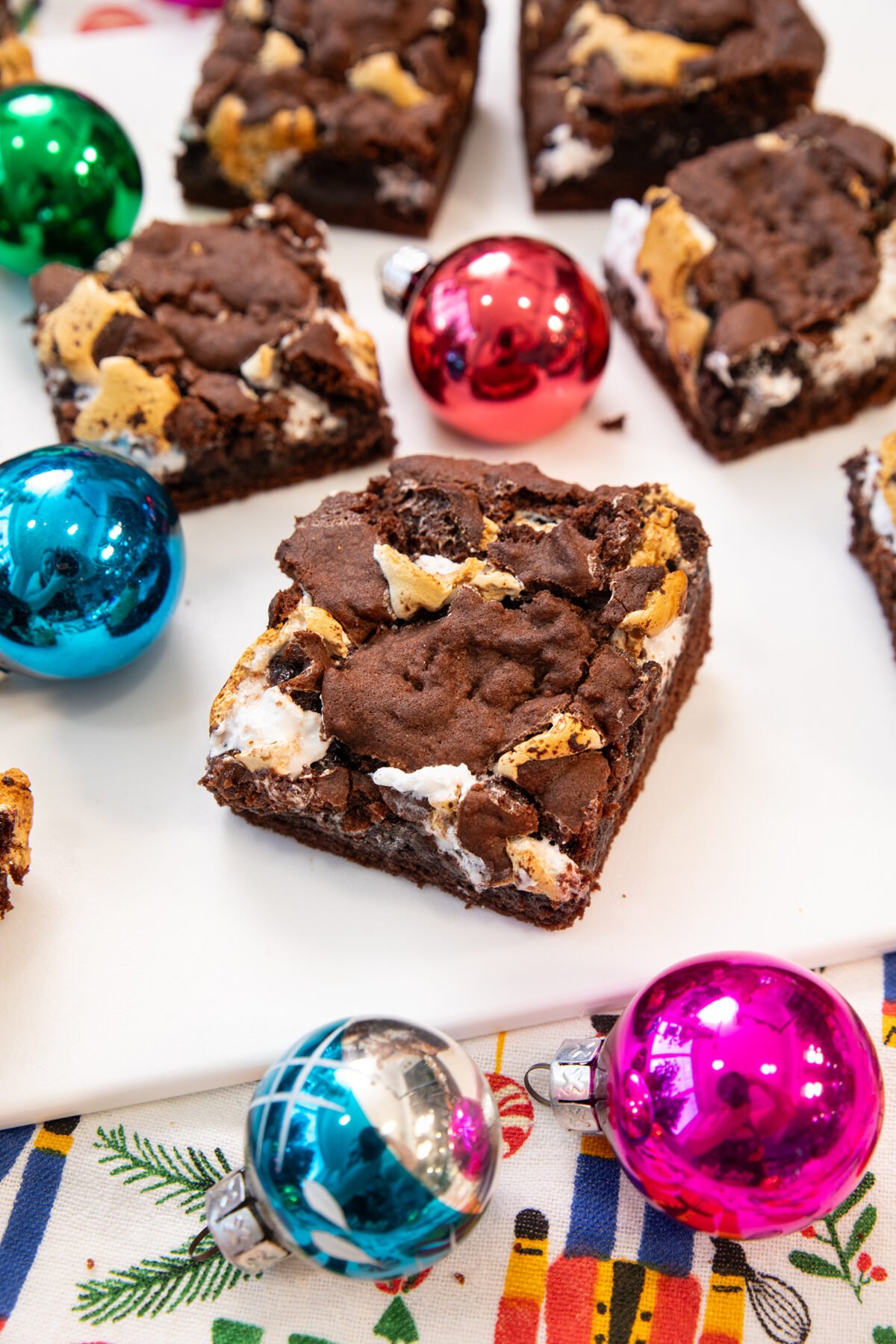 marshmallow brownies with Christmas decorations around them on a white counter