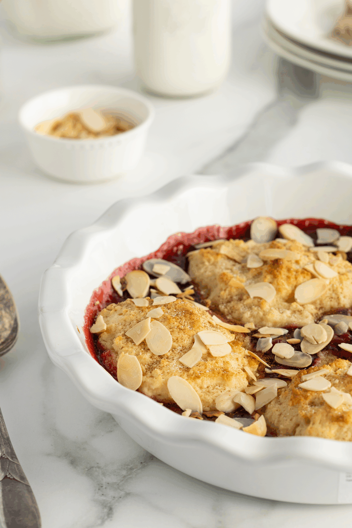 A bowl of dessert with a spoon and a fork.