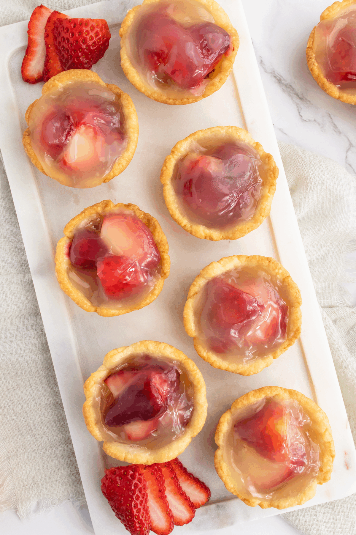 A group of fruit tarts on a white plate.